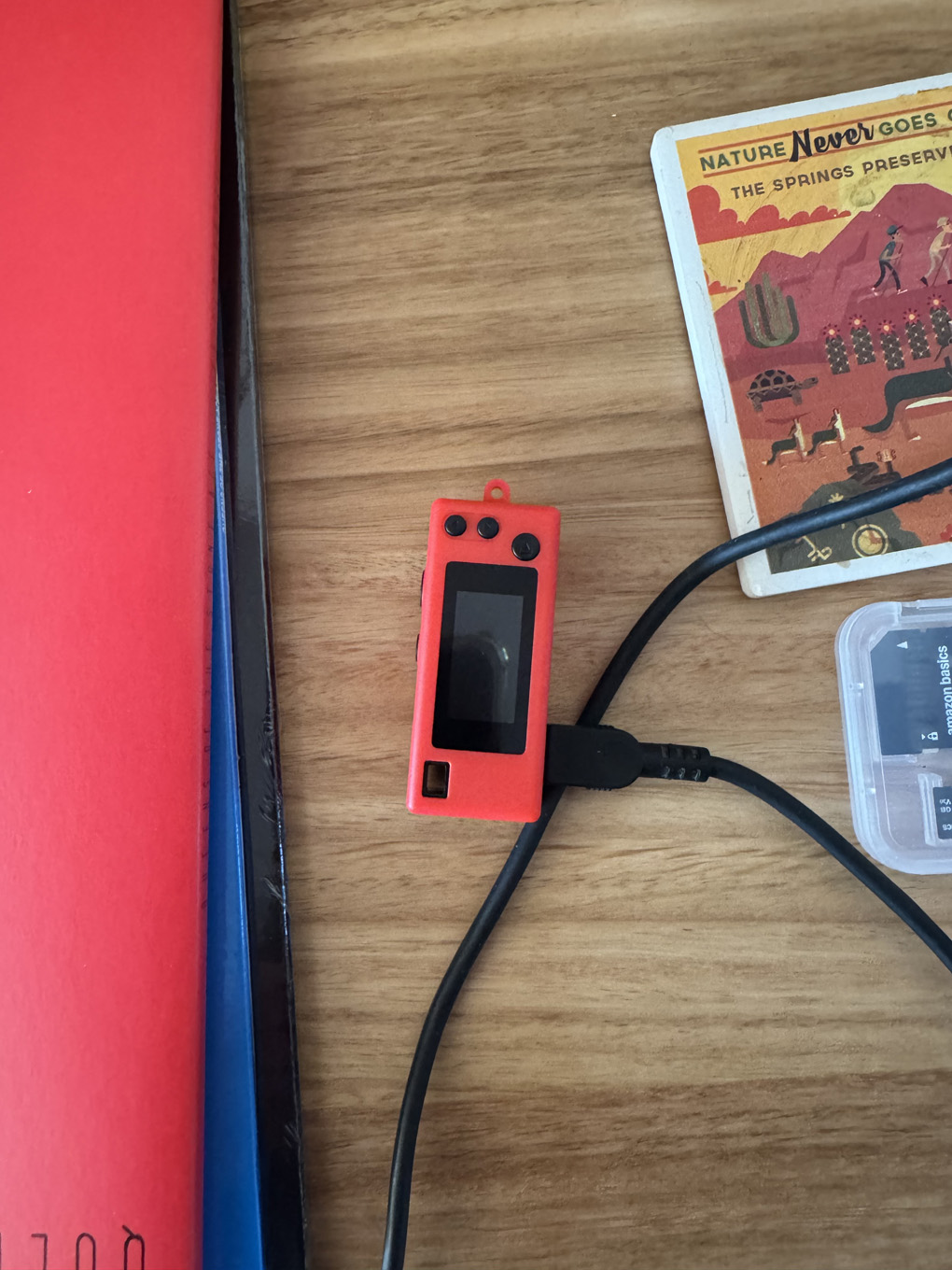 Small digital camera on a desk next to records and a coaster