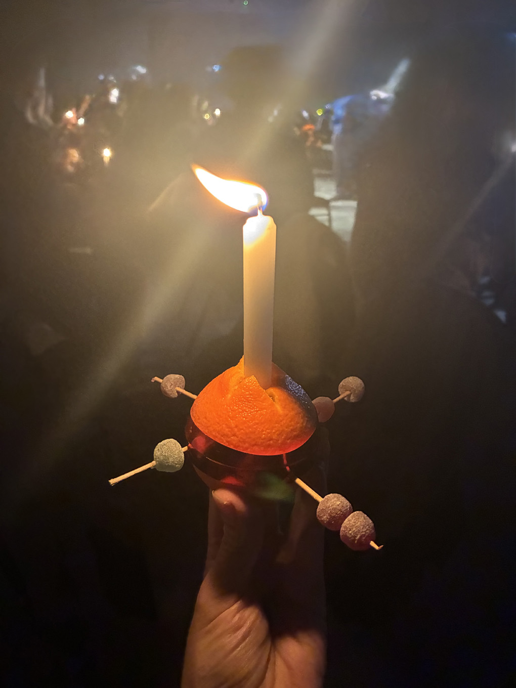 A Christingle orange and candle with sweets etc