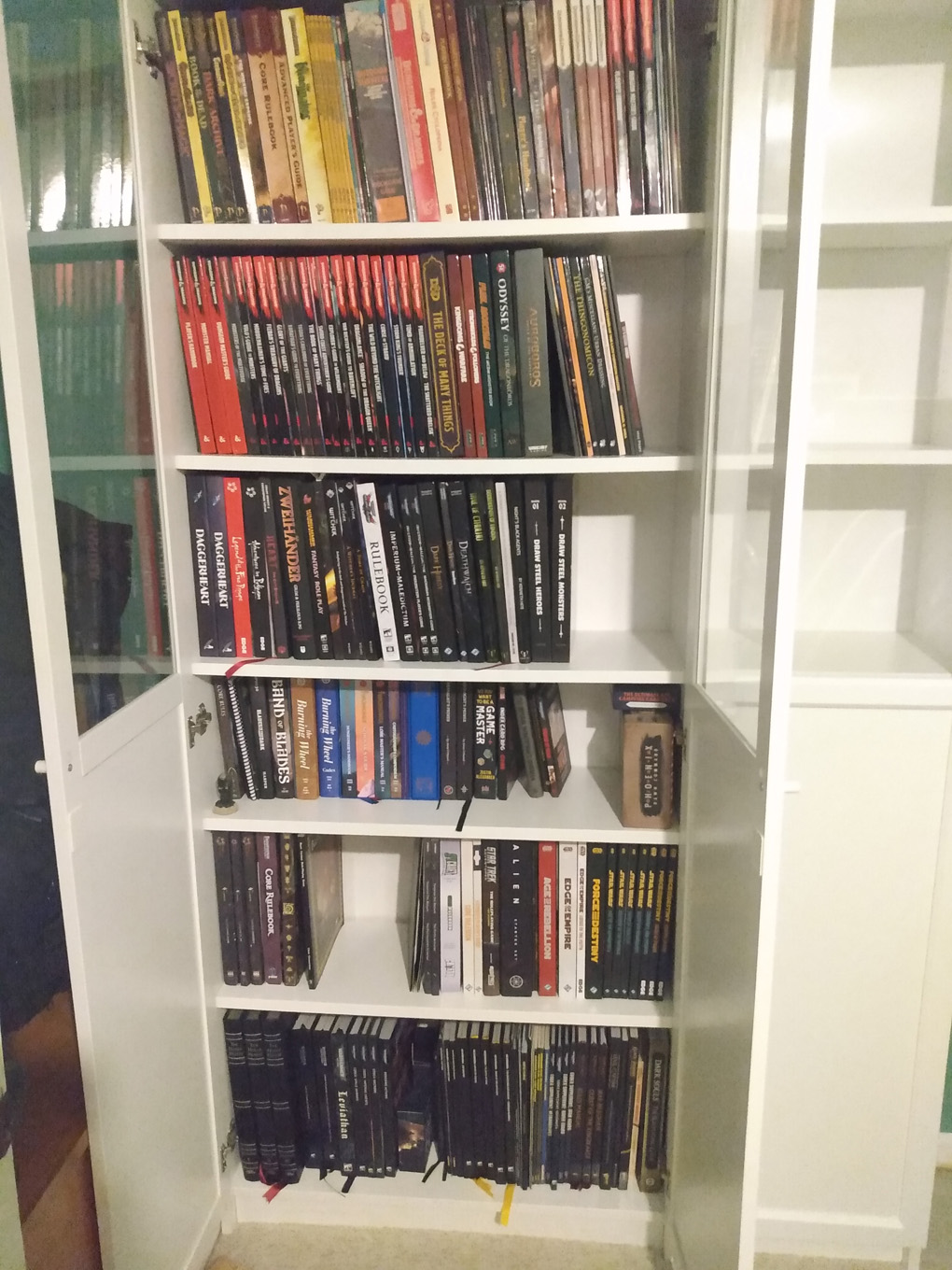 An IKEA Billy bookcase sits mostly full of large books