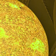 Large sculpt of the sun hanging in the middle of a Georgian hall