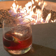 Drink on a table overlooking a fire pit