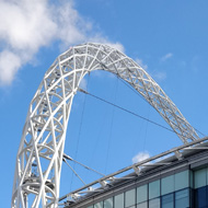 Wembley stadium and arch, under a blue sky.