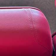 Looking down at some bright red padded seating in a sports stadium
