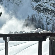 Snow coming down a mountain, viewed from a balcony