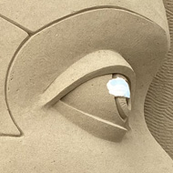 An automaton's head carved out of sand.