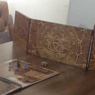 A table with a map, miniatures and dungeon master's screen all set up ahead of play.