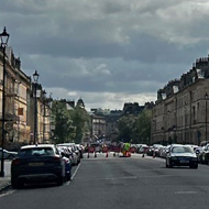 A view of a closed Bath street with celebrations in the distance