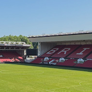 An empty Bristol City football stadium, with red and white seating spelling out the name of the club