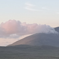 Slievemore mountain surrounded by sheep and fields at dusk