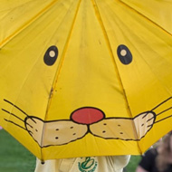 Child holding a large yellow umbrella