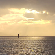 Sun setting over the mouth of a river