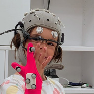 Child wearing electronics in a hat and glove