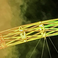 A packed Wembley Stadium at night with the crowd wearing glowing wristbands creating rainbow colored patterns across the stands. The iconic stadium arch is lit in rainbow colors with smoke rising into the night sky, and a large stage is visible at the bottom.