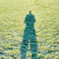 Image of a long cast shadow on a sunny, frosty morning. Makes the legs of a runner look infeasibly long