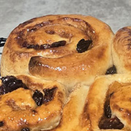 A tray of freshly baked cinnamon buns in front of the recipe