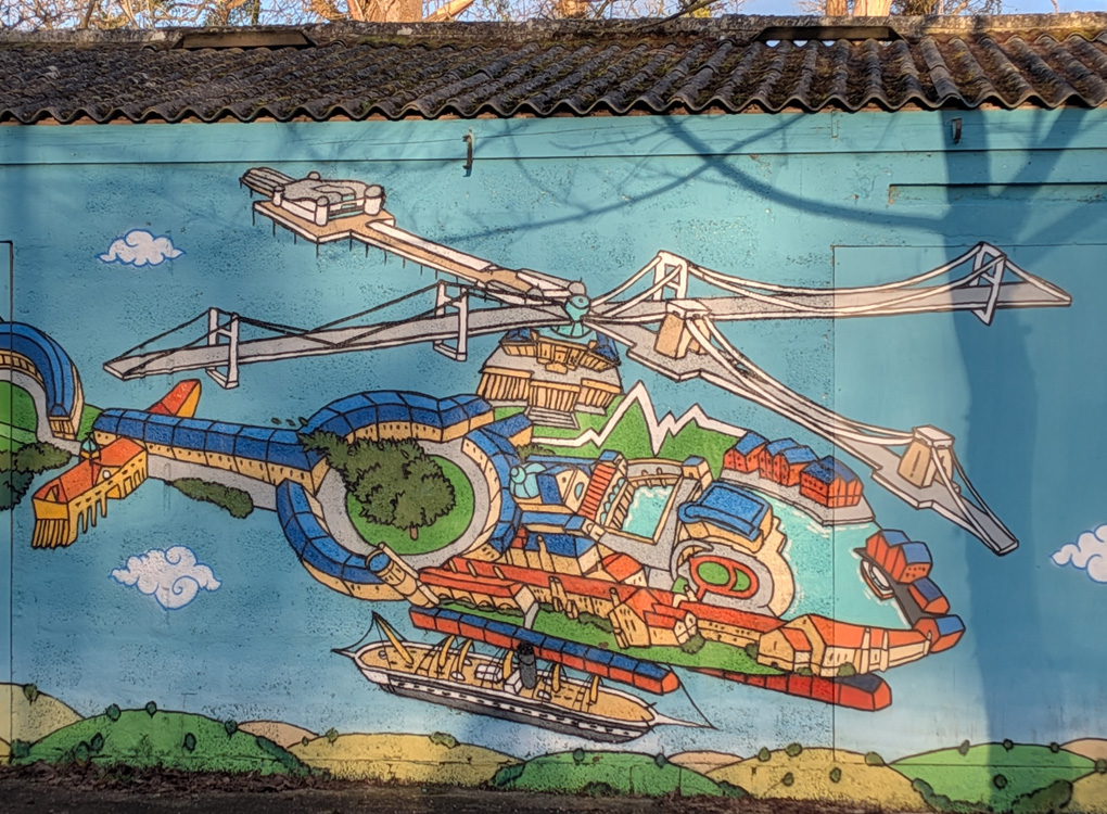 I spied a mural of a helicopter with a difference - depicting many cool structures within it of glass walkways, parcs, woods, and many cool buildings. Under the helicopter is suspended a lifeboat. Someone had a great imagination.