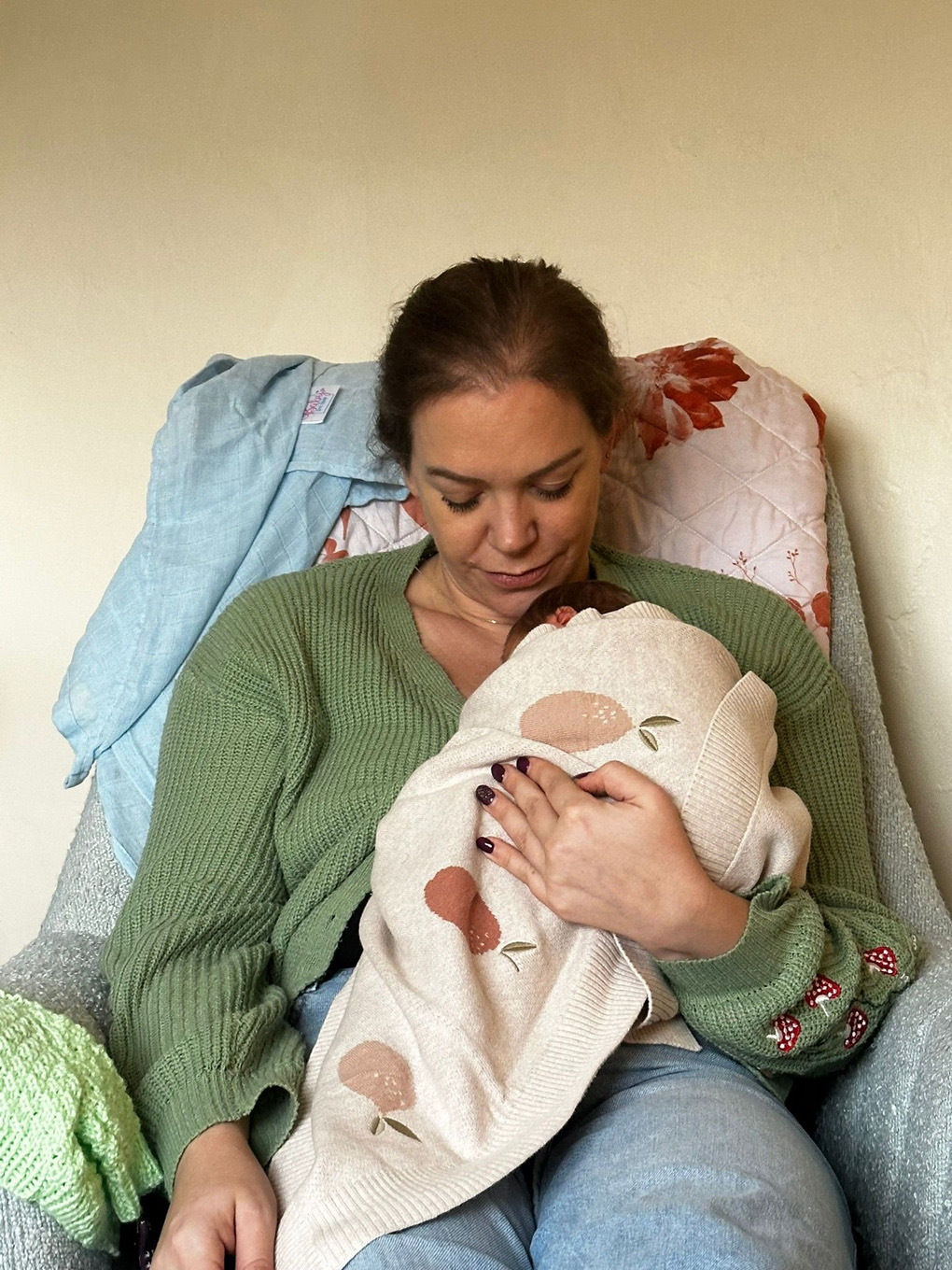 Lady sitting in a chair holding a baby