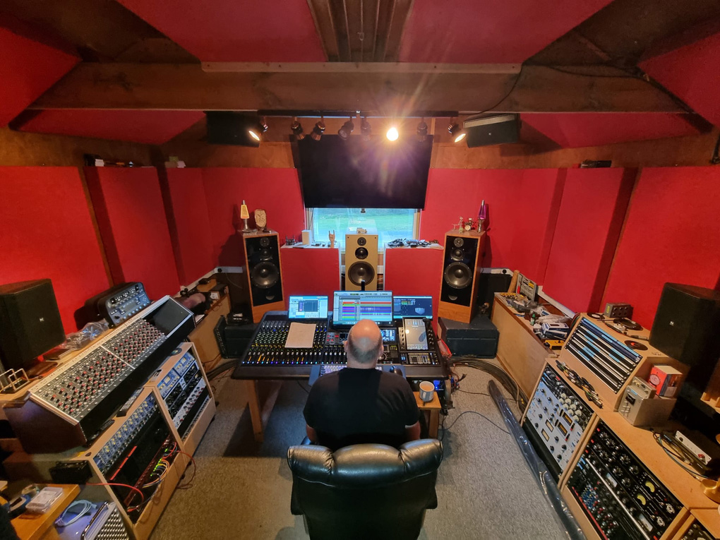 Stephen seated back to the camera in a mastering studio listening to the music.