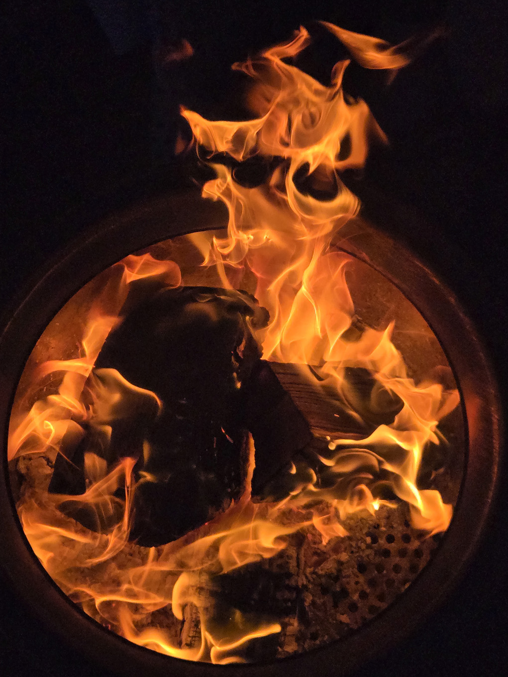 A circular fire pit, with a fire, photo taken from above