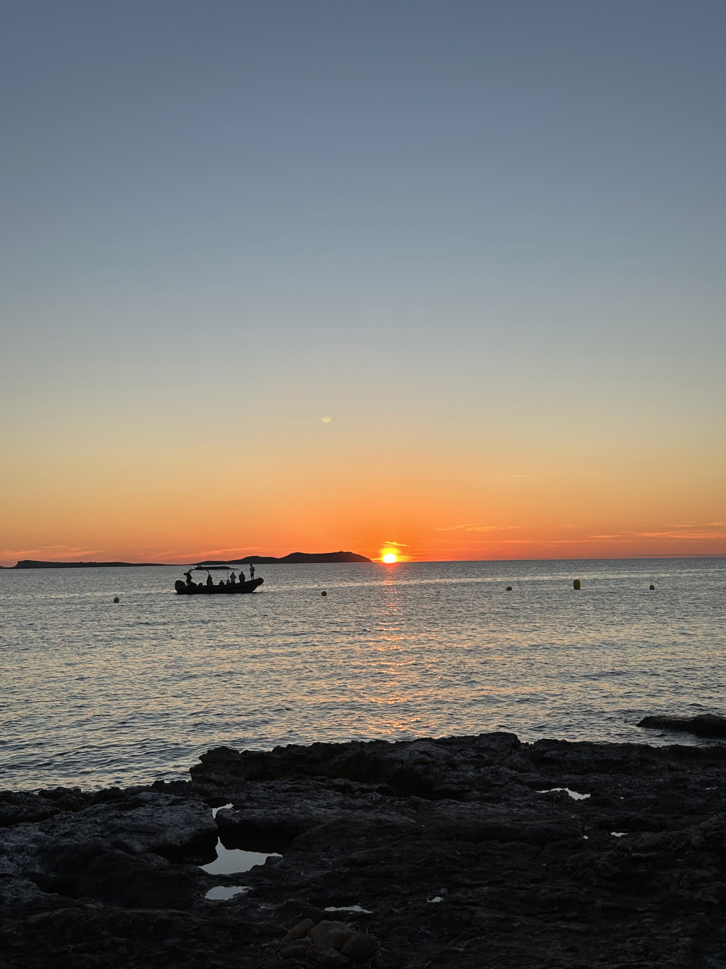 Sunset over the sea with a boat going past