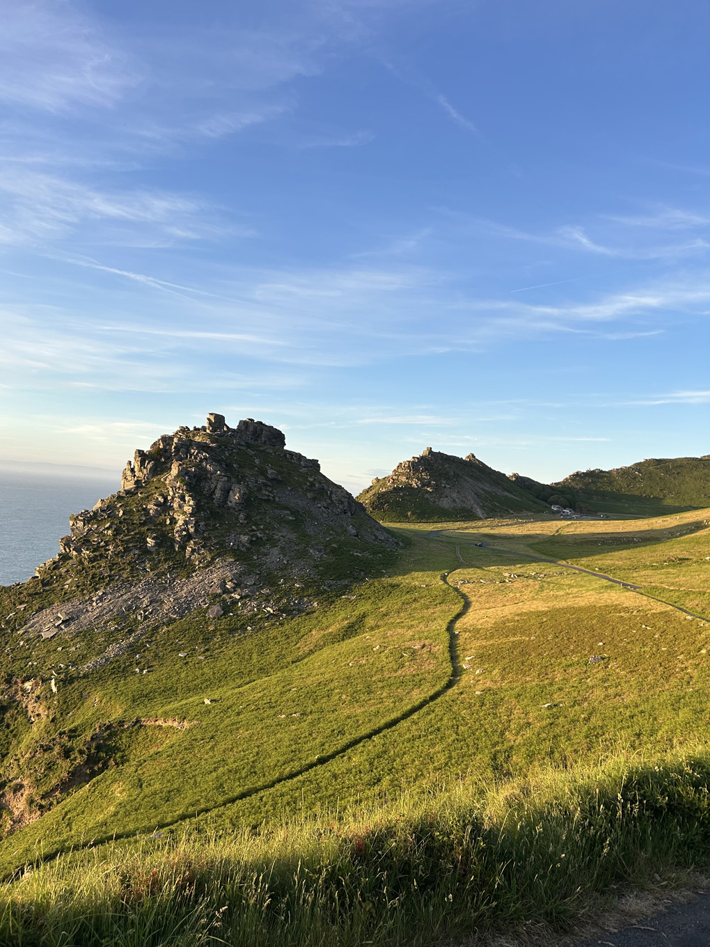 Rocks and hills with the sea behind them.