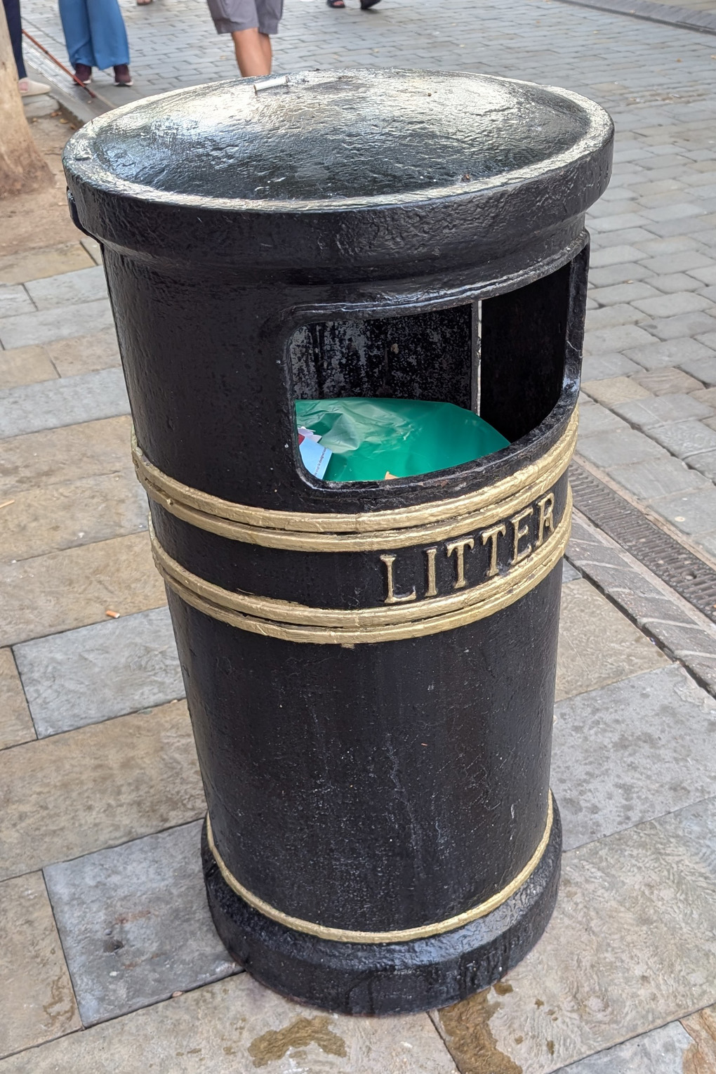 A standard, circular British bin you'd see on most UK high streets - cylindrical, metal with the word 