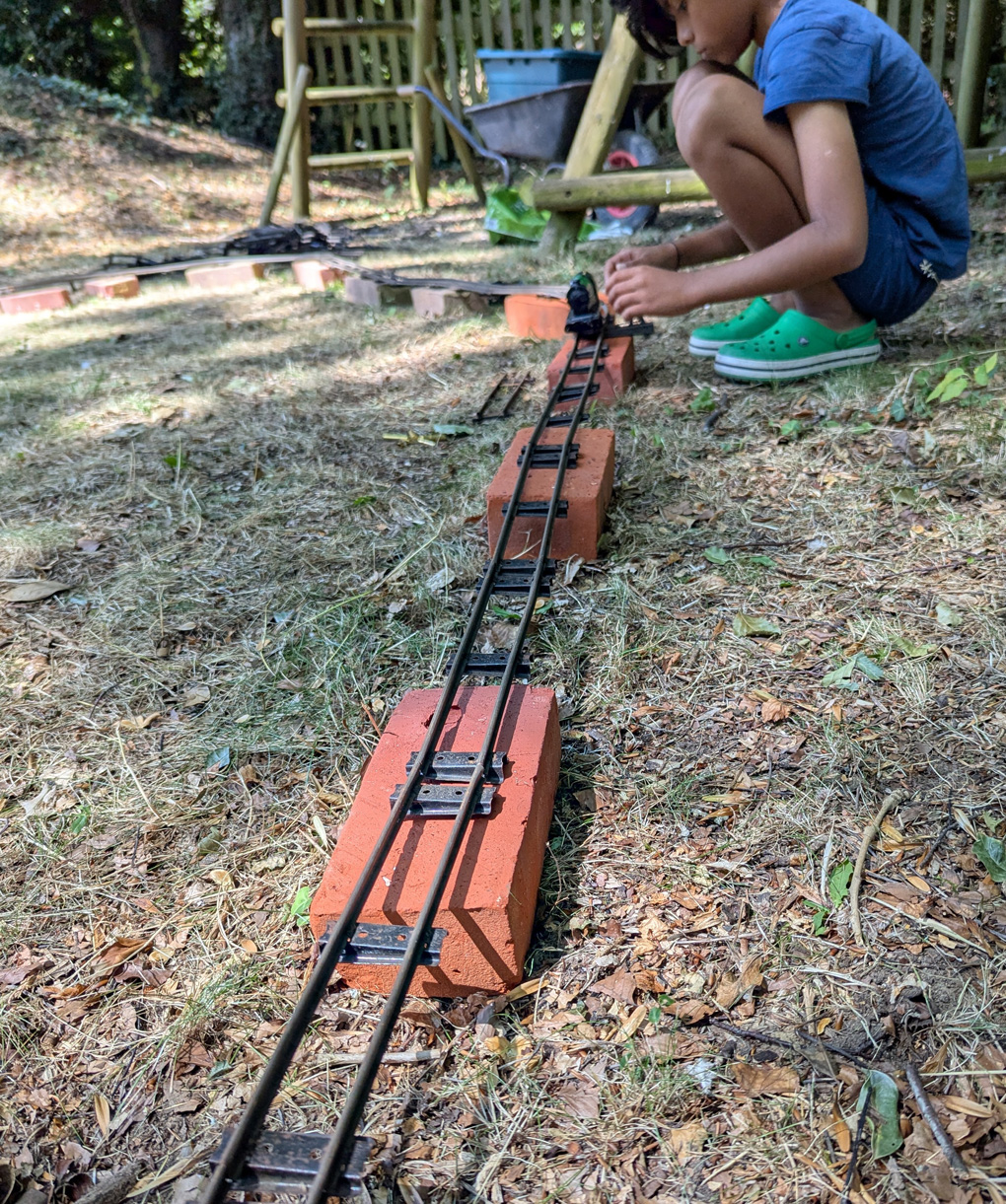 Vintage O-Gague track and train outside on some bricks