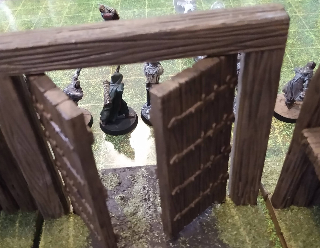 28mm miniatures sit on a laminated map with a plastic wall on the near side of the view