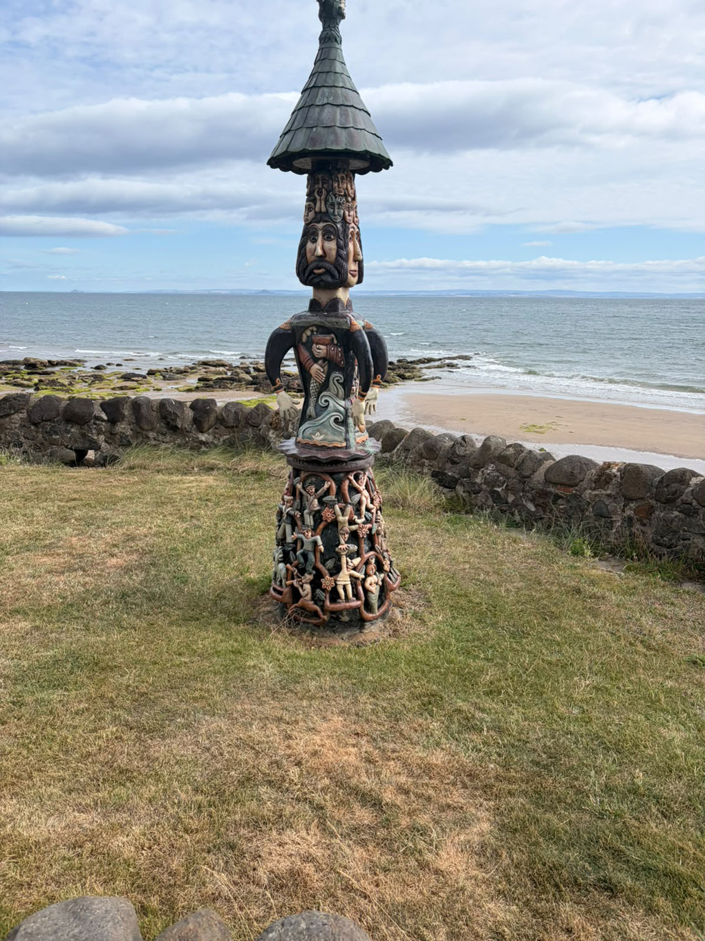 Totem pole of many faces and arms, on the coast of Scotland