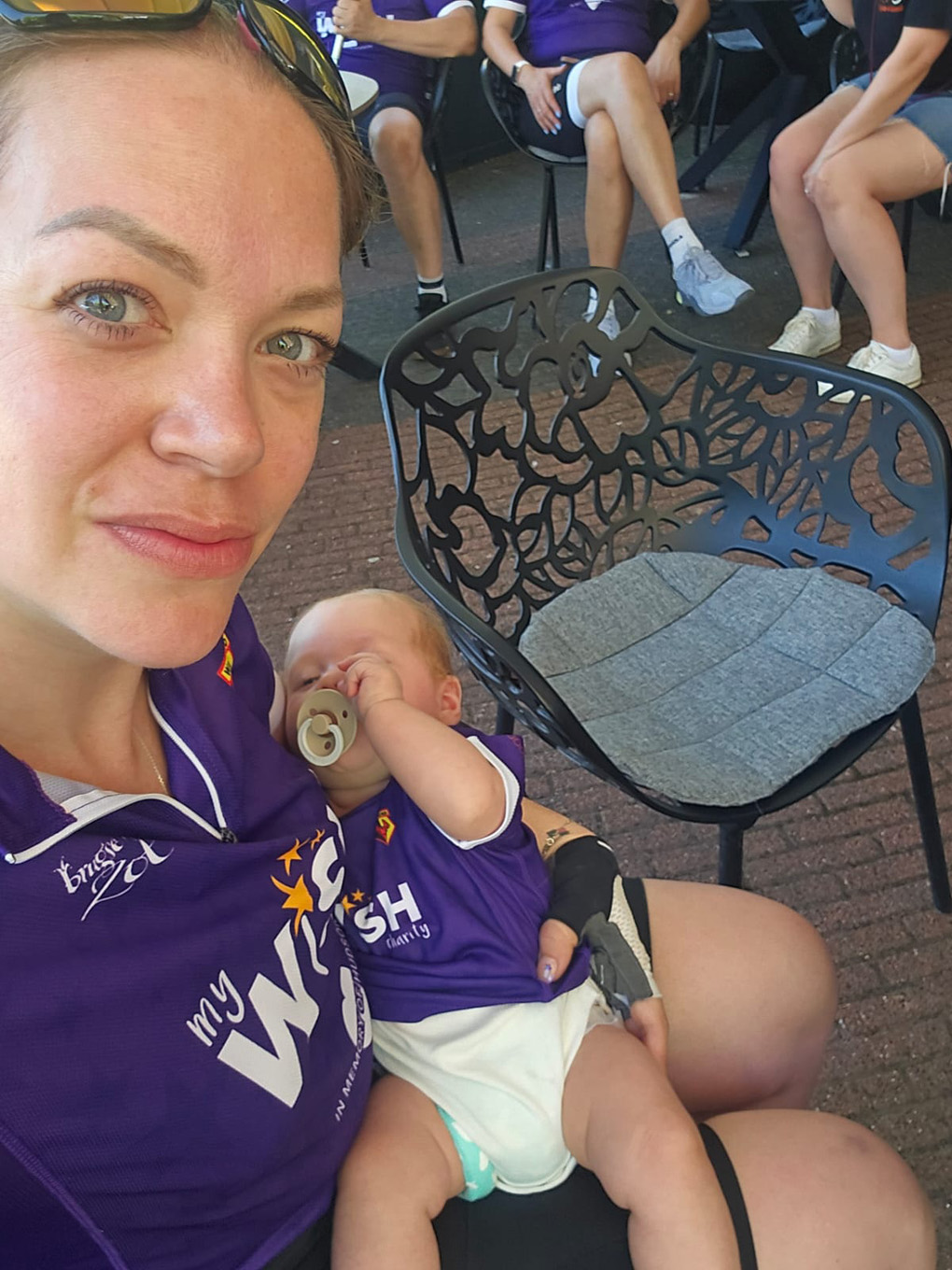 Mother holding baby at a fundraising event.