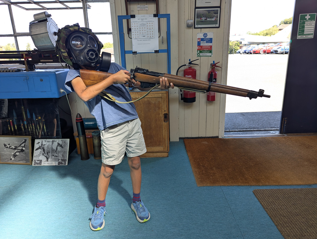 Boy in a gas mask holding a rifle