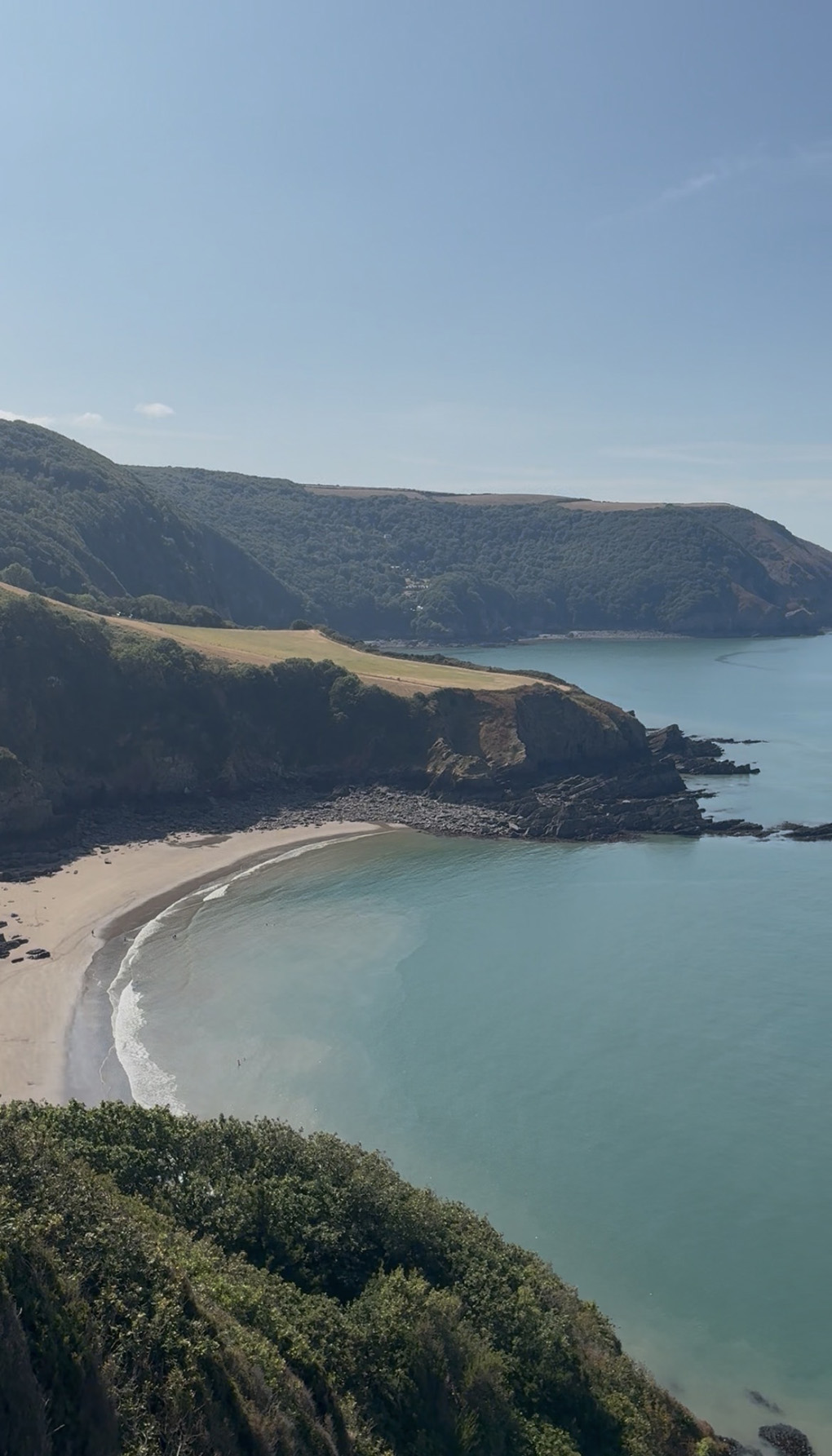 A photo of the sea sand and cliffs at Lee Bay in Devon looking down from the cliff top
