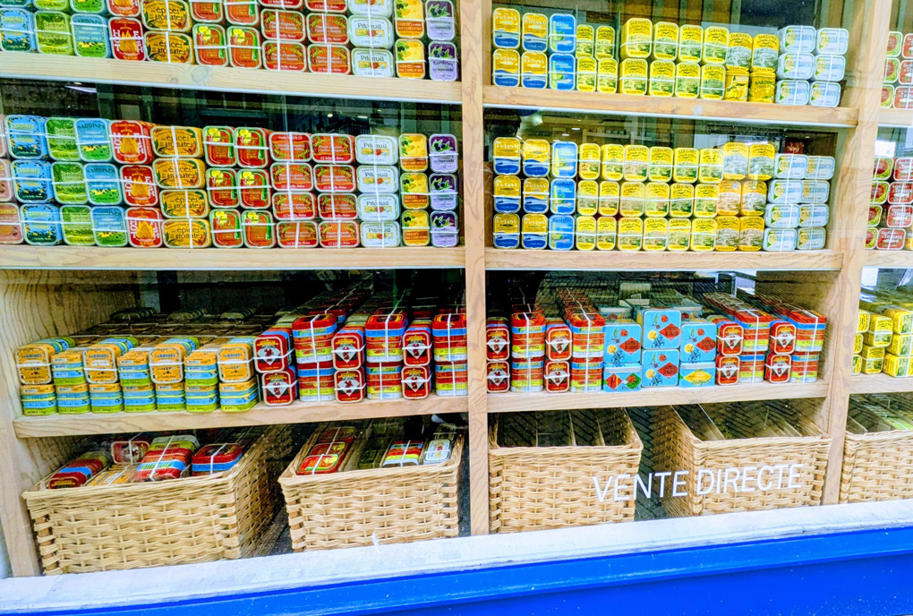 Many different varieties of tinned fish in colourful tins in a French shop