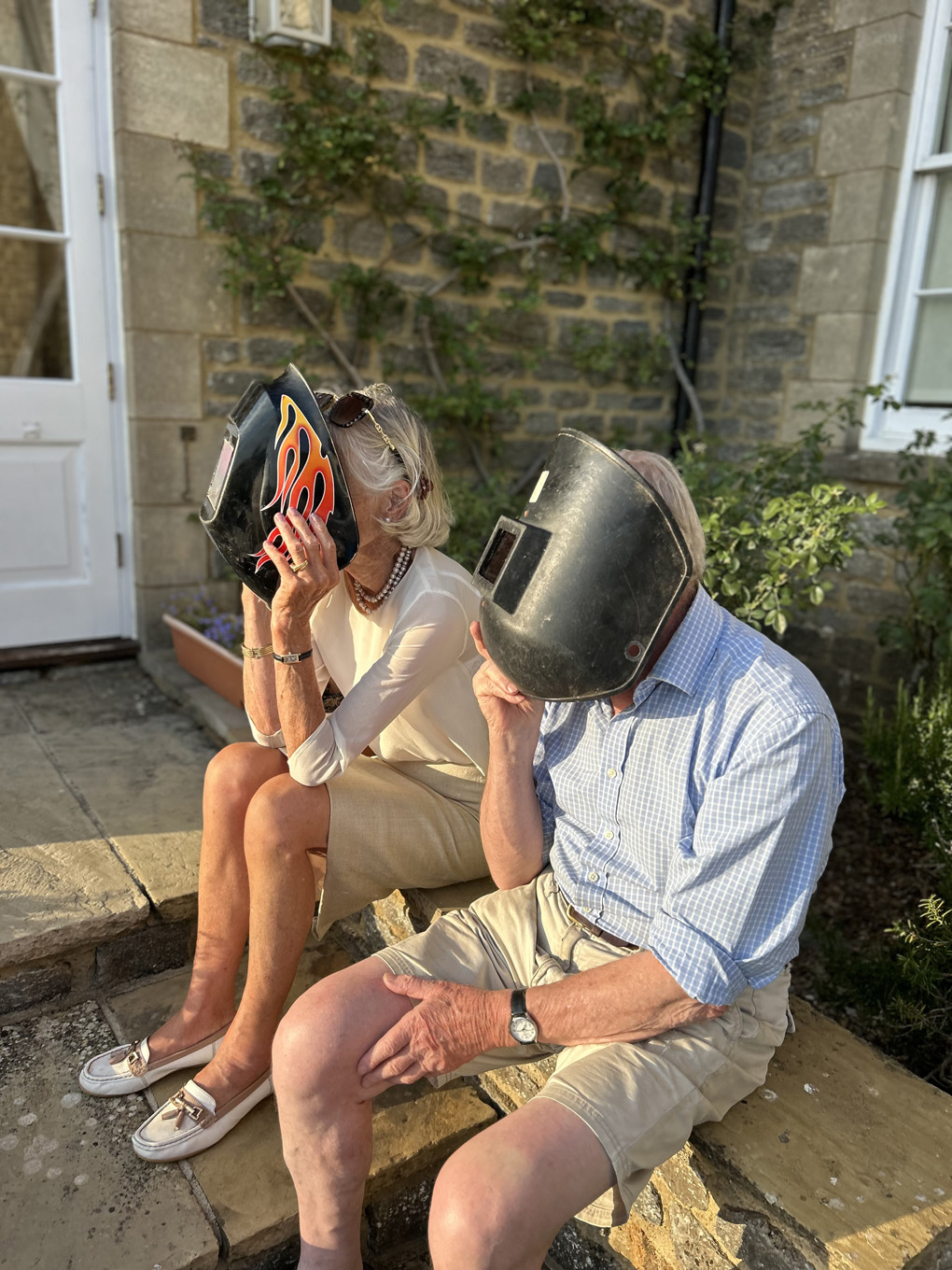 Two older people wearing welding masks