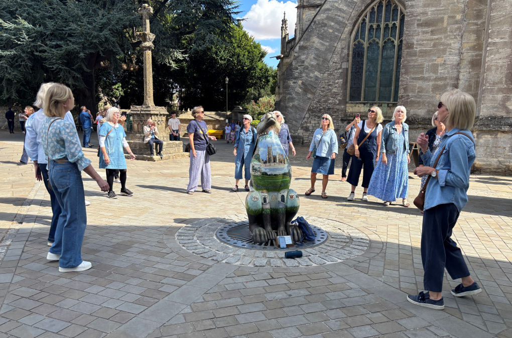 Around the painted five-foot hare outside the parish church in the West Market Place in Cirencester, there's a semi circle of women mid song, whilst passersby stop to watch and listen.