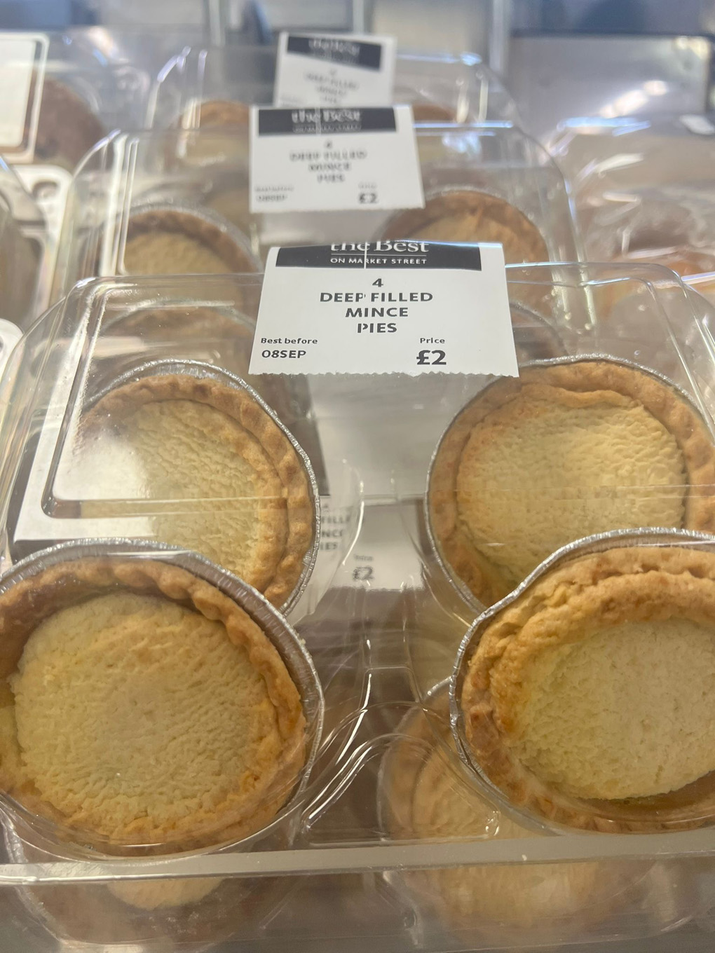 Four mince pies in a box on a store shelf