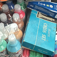 Car front passenger seat, with paint, chess, cheese a folder, a cup, pipe cleaners and Pom poms..