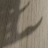 A long shadow of a horned dragon model is cast on a desk