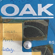 The label of a record, blue, with a hand-written track list attached with yellowed tape, and the band name 