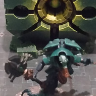 Warhammer models are arranged on a cardboard map, each is silver and glows green