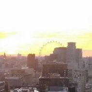 London skyline looking West over Borough Market from an elevated position. The sun sets near the London Eye in the distance.