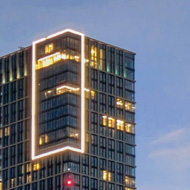 Skyline of tall buildings with lights and the twilight sky.