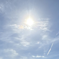 A green valley under bright blue, slightly cloudy skies