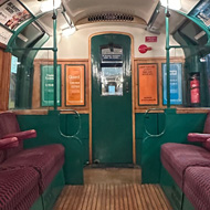 A 1938 rolling stock tube train with wooden floors, green and white paint and red moquette seats.