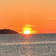 Sunset over the sea with a boat going past