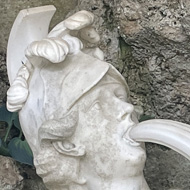 A zoomed in portion of a phallic stone water fountain