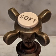 A marble sink with three taps. They are, left to right, Hot, Soft and Cold.