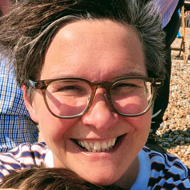 Five people on the beach, all wearing glasses