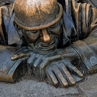 Bronze statue of a man crawling out of a man-hole in Bratislava.