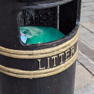 A standard, circular British bin you'd see on most UK high streets - cylindrical, metal with the word 